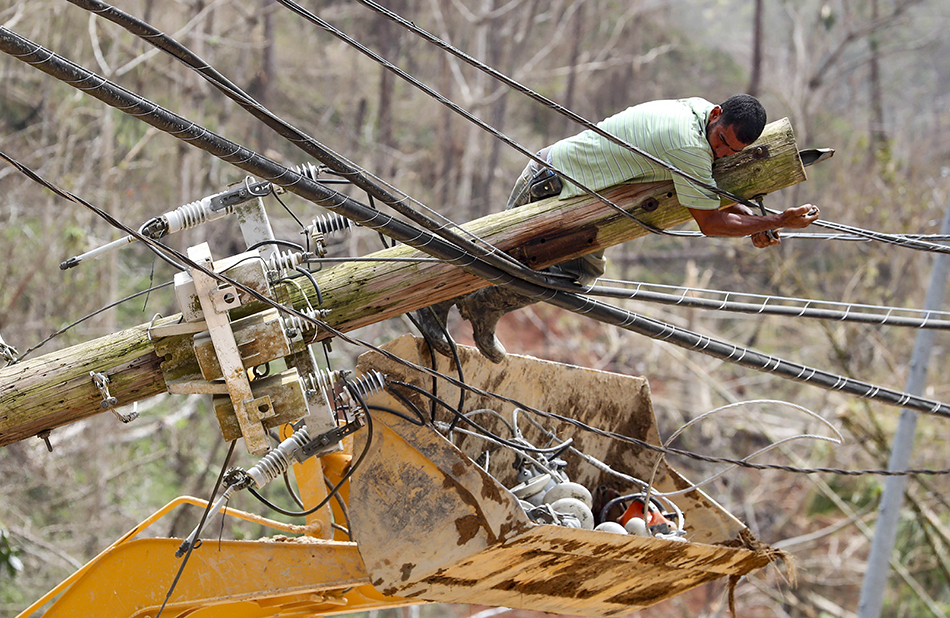 Puerto Rican civilian fixing the electric grid from a bulldozer after Hurricane María